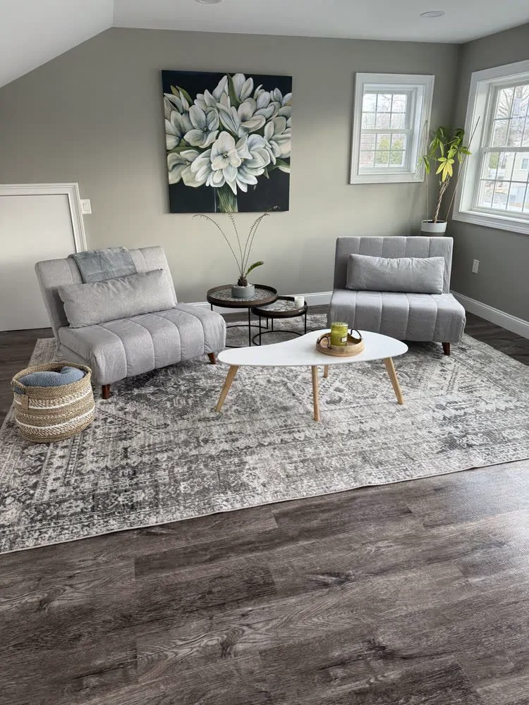 A living room with a grey sofa and a patterned rug after a Pura Clean visit