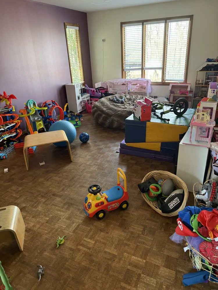 A playroom with toys spread across the floor before organizing