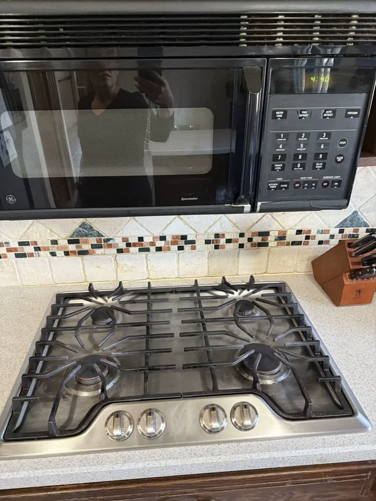 The same gas stovetop, spotless, after cleaning